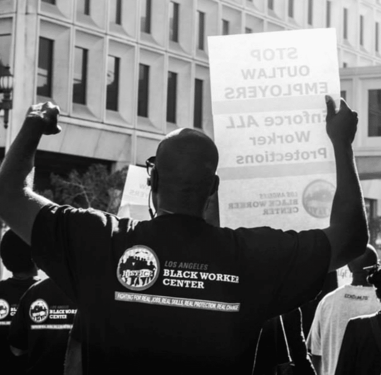 LA Black Worker Center representative holding a sign